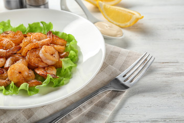 Plate with fresh tasty shrimp basket on table