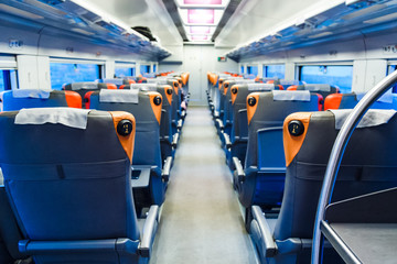 Rows of passenger seats in railway coach. Passenger transport interior. Travel background.