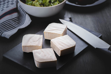 Feta cheese with greek salad and tomatoes on the brown wood table 