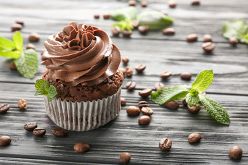 Tasty chocolate cupcake on wooden table
