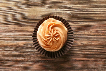 Tasty chocolate cupcake on wooden background