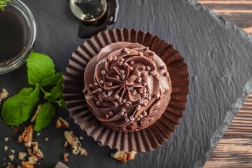 Tasty chocolate cupcake on table