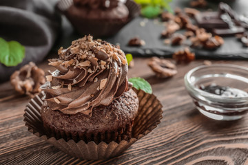 Tasty chocolate cupcake on table