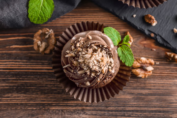 Tasty chocolate cupcake on table