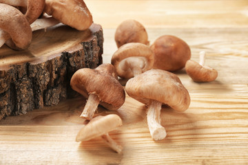 Raw shiitake mushrooms on wooden table, closeup