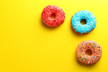 Tasty glazed donuts on color background
