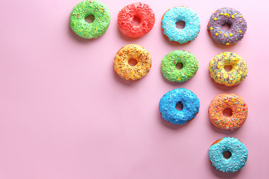 Tasty glazed donuts on color background