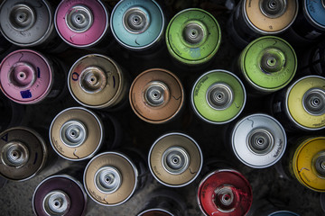 Many colorful cans of aerosol paint for painting walls with graffiti. Street art