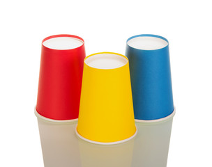 Inverted red, yellow and blue disposable tumbler isolated on white
