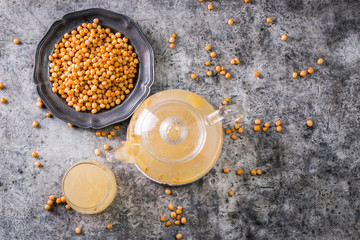 Tea of sea-buckthorn berries with branch on dark background.healthy drink