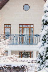 Winter city plot. Snow-covered house with balcony