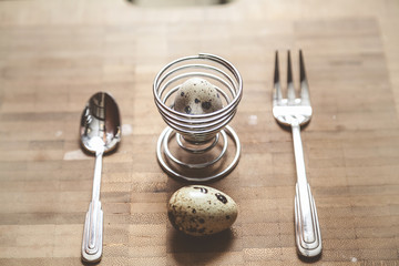 Quail Egg lay on board. Second egg inside stand.