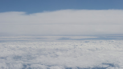 aerial shot from plane flying above the clouds in daytime