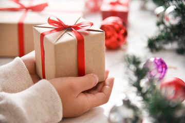 Kid hands holding a brown present box.