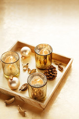 Chritsmas candles on the wooden table. Winter pine cone decoration with ornaments, glasses and leaves. Copy space.