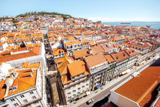 Cityscape view on the old town with central avenue and castle hill on the horizon during the sunny day in Lisbon city, Portugal