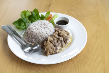 Steamed rice with stew pork in sauce and fresh vegetable side dish. this  is thai food.