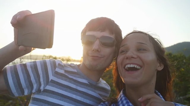 Romantic couple taking selfie video by sunset during vacation. Slow motion. 1920x1080