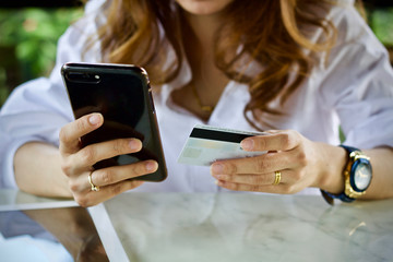 Woman using laptop smartphone paying online 