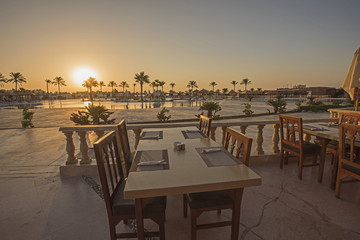 Outdoor dining table  with sunset in tropical hotel resort