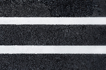 Fototapeta premium Two parallel white marking line on the asphalt road (background, texture, abstract)