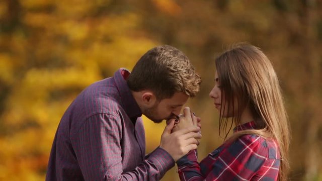 A loving couple walks in the autumn in the park. A love story on a sunny autumn day. lake and bringe .