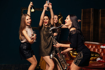 Women drinking champagne and dancing at party