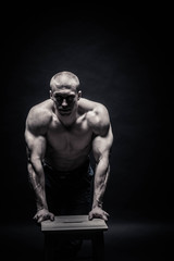 Fototapeta na wymiar Portrait of a handsome male bodybuilder, on a black background isolated. monochrome. The concept of a photo of competing sports, health, fitness
