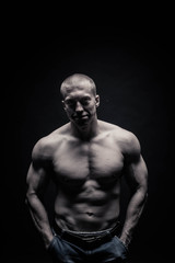 Fototapeta na wymiar Portrait of a handsome male bodybuilder, on a black background isolated. monochrome. The concept of a photo of competing sports, health, fitness