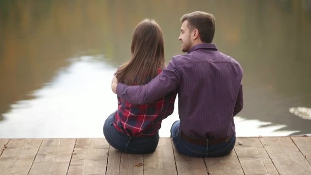 A loving couple walks in the autumn in the park. A love story on a sunny autumn day. lake and bringe .