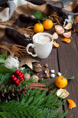 Hot Christmas drinks, coffee, cocoa or chocolate with marshmallows. Christmas composition on wooden background, branches, Christmas trees, Christmas decorations, tangerines.