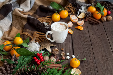 Hot Christmas drinks, coffee, cocoa or chocolate with marshmallows. Christmas composition on wooden background, branches, Christmas trees, Christmas decorations, tangerines.
