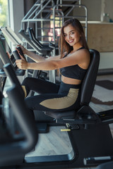 Fototapeta na wymiar Smiling woman on gym machine