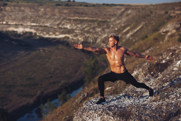 Bare-chested man lunging outside