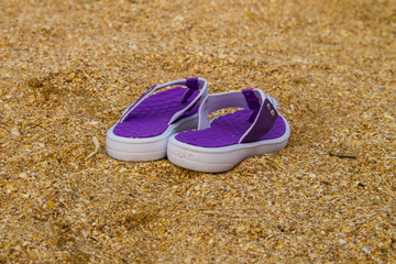 Pair of flip flops on a sandy sea beach