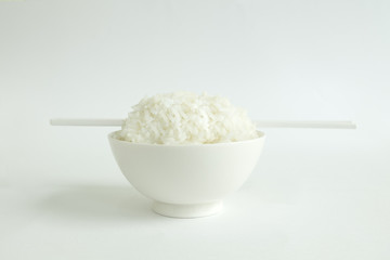 RICE BOWL WITH CHOPSTICKS
Steamed rice in a white bowl served with white chopsticks on a white background. 