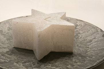 Kerze in Schale in Sternform als Dekoration an Weihnachten