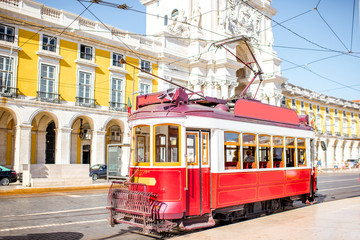 Old tourist tram on the central square with Augusta arch on the background in Lisbon, Portugal