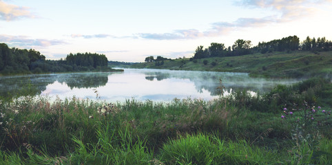 Foggy summer landscape with river.