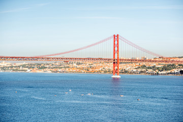Landscape view on the Tagus river and the famous 25th of April Bridge during the morning light in Lisbon city, Portugal