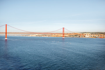 Wide angle view on the Tagus river and the famous 25th of April Bridge during the morning light in Lisbon city, Portugal