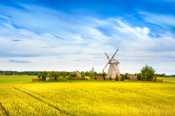 Wooden windmill on background field and sky. Dudutki village, Minsk Region, Belarus