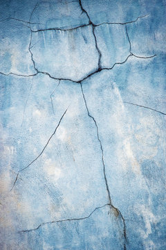 old pale blue wall with cracks