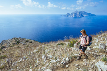 Woman with daypack on the way to the end of the amalfi coast trail/ Punta Campanella, italy, europe - obrazy, fototapety, plakaty