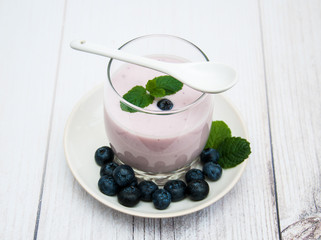 Glass with blueberry yogurt on a table