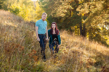 Obraz premium Young loving married couple on the river bank, man and beautiful girl on nature in summer