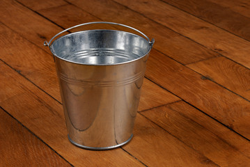 Metal bucket on old wooden floor