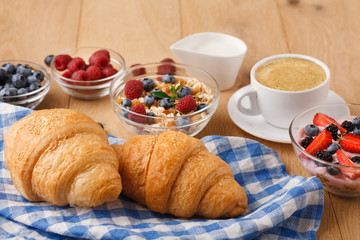Continental breakfast with croissants and berries on natural wood