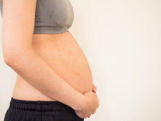 Pregnant woman in sport bar. Pregnant woman holds her hands on belly. belly pregnent woman.