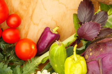 Harvest of fresh vegetables on a wooden background, in garden background. Top view. Garlic, beet, zucchini, kohlrabi, cauliflower, pepper, tomatoes, potatoes, basil, cucumber, dill.